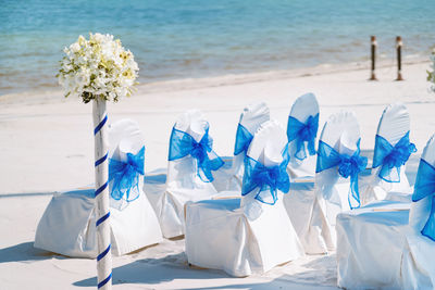 Scenic view of blue sea and white flowers on beach
