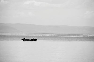 Boat sailing on sea against sky