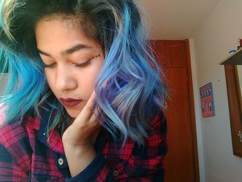 Close-up of young woman with dyed hair at home