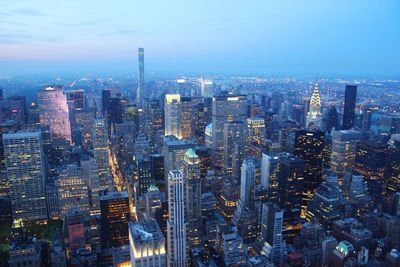 High angle view of chrysler building in illuminated city during sunset