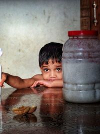 Portrait of smiling boy with drinking water on table