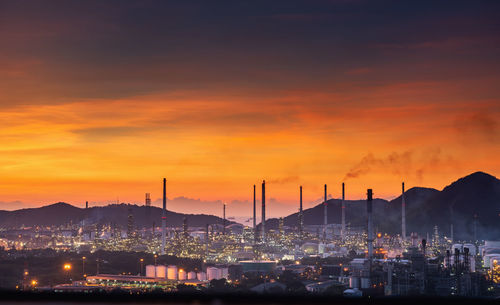 Illuminated cityscape against sky during sunset