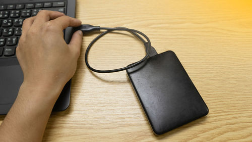 Close-up of hand holding eyeglasses on table