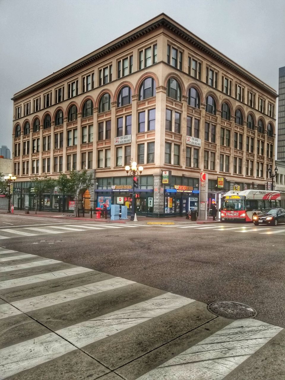 CARS ON ROAD BY BUILDING AGAINST SKY