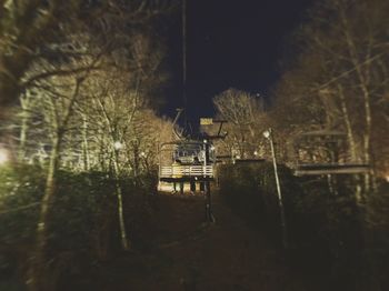 Bare trees against sky at night