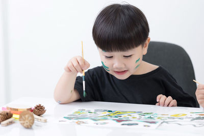 Portrait of cute boy holding table