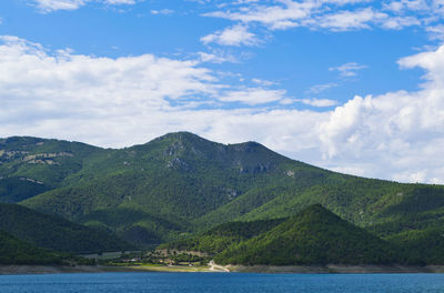 Scenic view of sea and mountains against sky