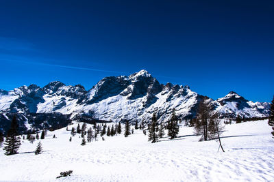 Snow covered mountains against clear blue sky