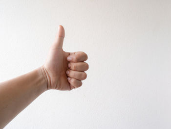 Close-up of human hand against white wall