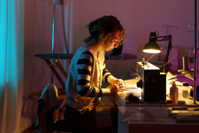 Fashion designer in atelier. young girl seamstress use sewing machine to create bespoke clothes