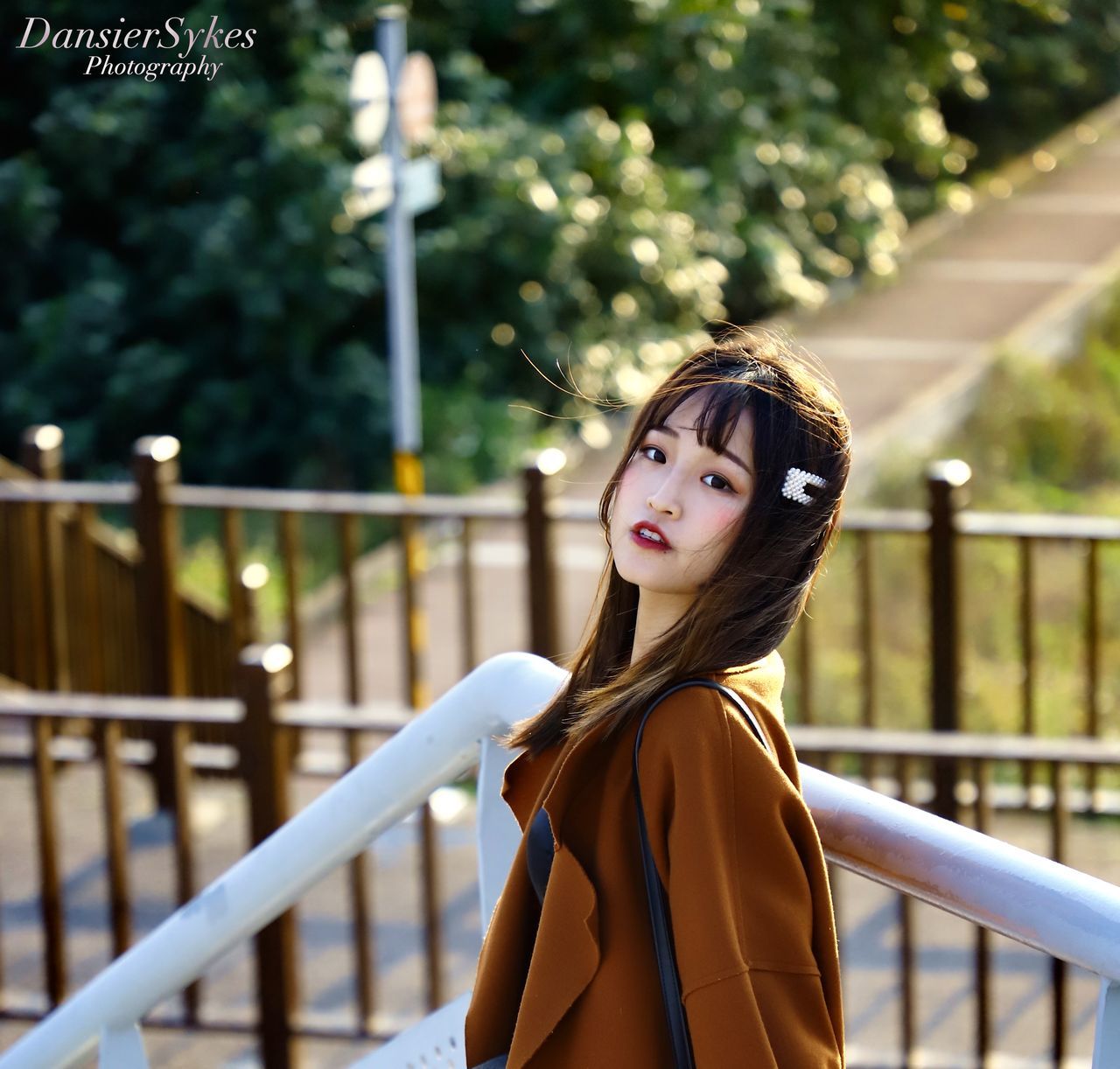 one person, railing, real people, focus on foreground, lifestyles, standing, leisure activity, young women, young adult, women, portrait, beautiful woman, day, looking at camera, beauty, hair, hairstyle, looking, outdoors, bangs