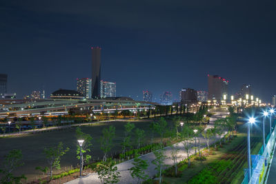 Illuminated buildings in city against sky at night