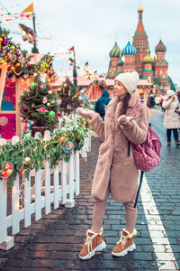 Woman standing on street with city in background