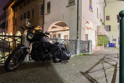 Bicycle parked on street against buildings in city