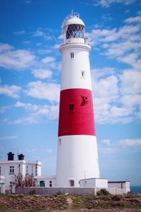 Lighthouse by sea against sky