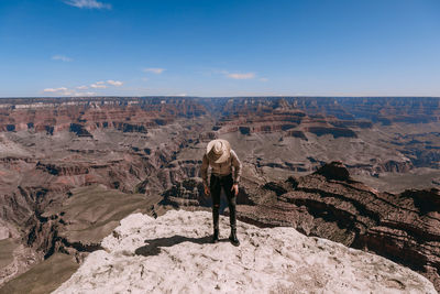 Rear view of man on rock against sky