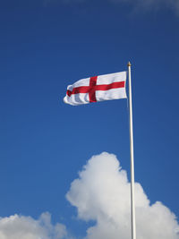 Low angle view of flag against blue sky