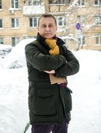 Mature man standing against building during winter