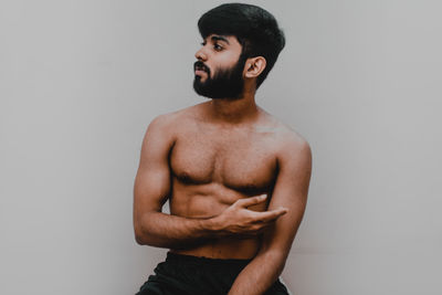 Young man looking away against white background