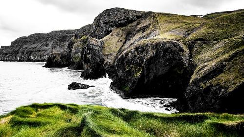 Scenic view of rocks in sea against sky