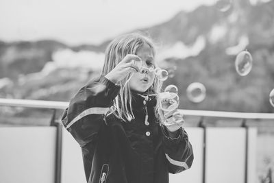 Cute girl blowing bubbles outdoors