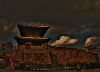 Low angle view of built structure against cloudy sky