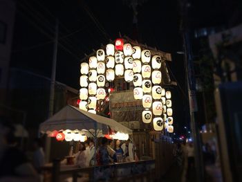 Illuminated lanterns hanging at store