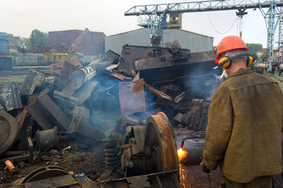 Worker welding scrap metal