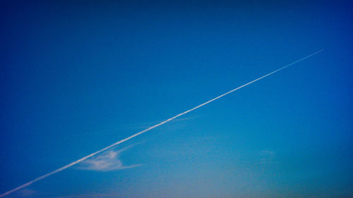 Low angle view of vapor trail in blue sky