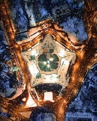 Reflection of illuminated buildings in puddle