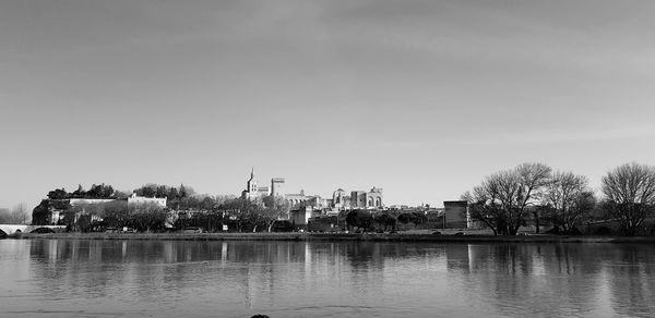 River by buildings against sky