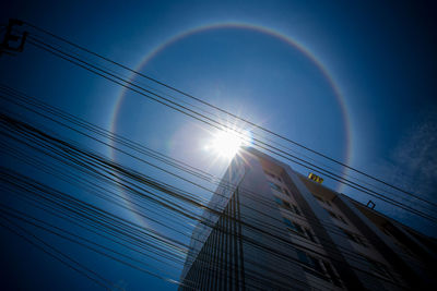 Low angle view of rainbow over building against sky