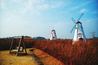 Traditional windmill on field against sky