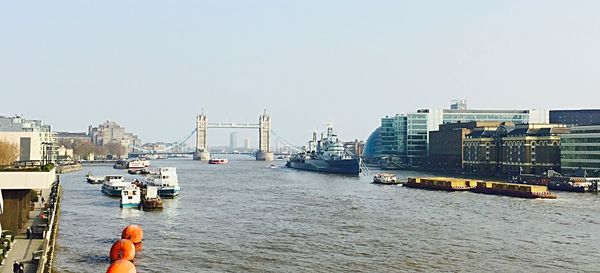 Boats in harbor with cityscape in background