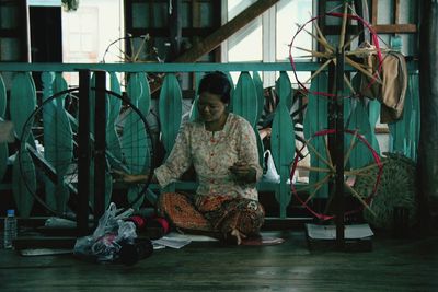 Woman working on spinning wheel at home