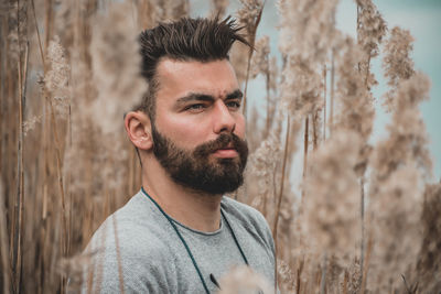 Portrait of young man standing against trees