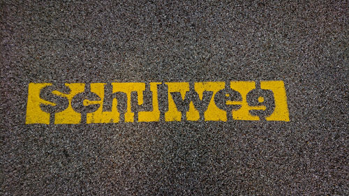 High angle view of yellow sign on road