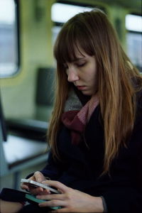 Woman using phone while traveling in train