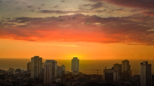Modern buildings against sky during sunset