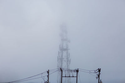 Low angle view of electricity pylon during foggy weather