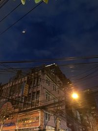 Low angle view of illuminated buildings against sky at night