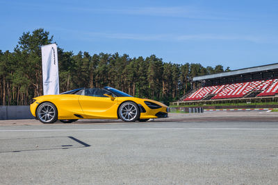 Yellow car on road against sky