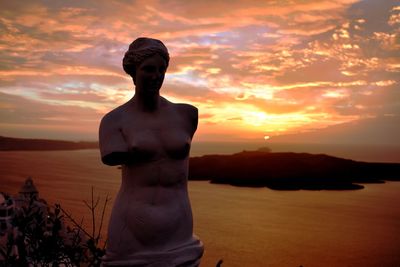 Statue against sea during sunset