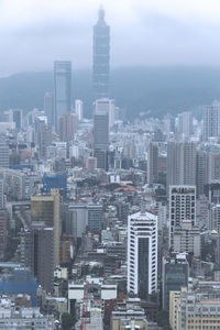 Aerial view of buildings in city against sky