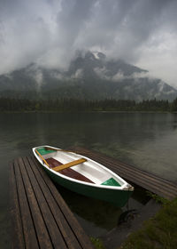 Boat moored in lake against sky