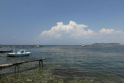 Sailboats moored on sea against sky