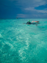 Person swimming in sea against sky