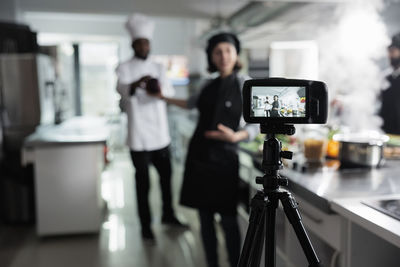 Woman with camera vlogging at restaurant