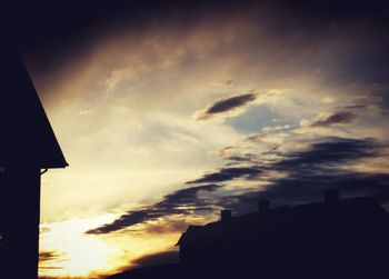 Buildings against cloudy sky at sunset