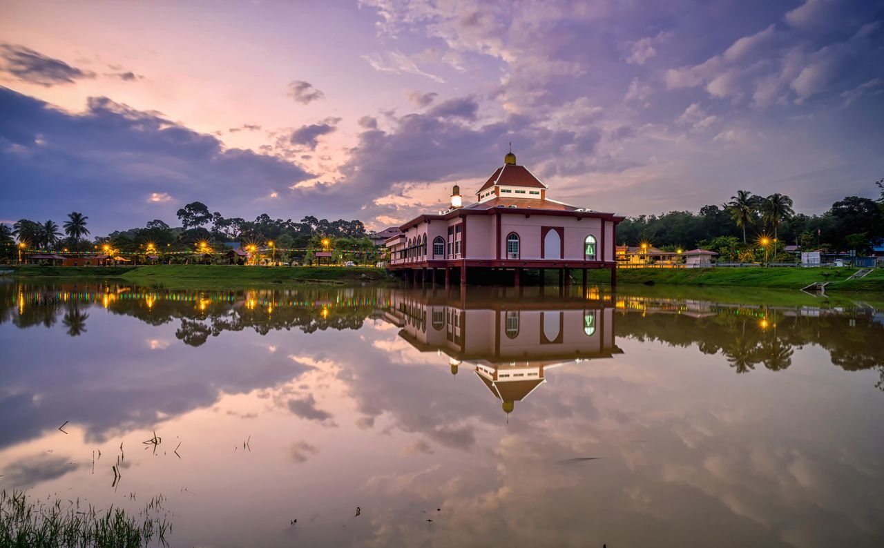 REFLECTION OF BUILDING ON LAKE DURING SUNSET